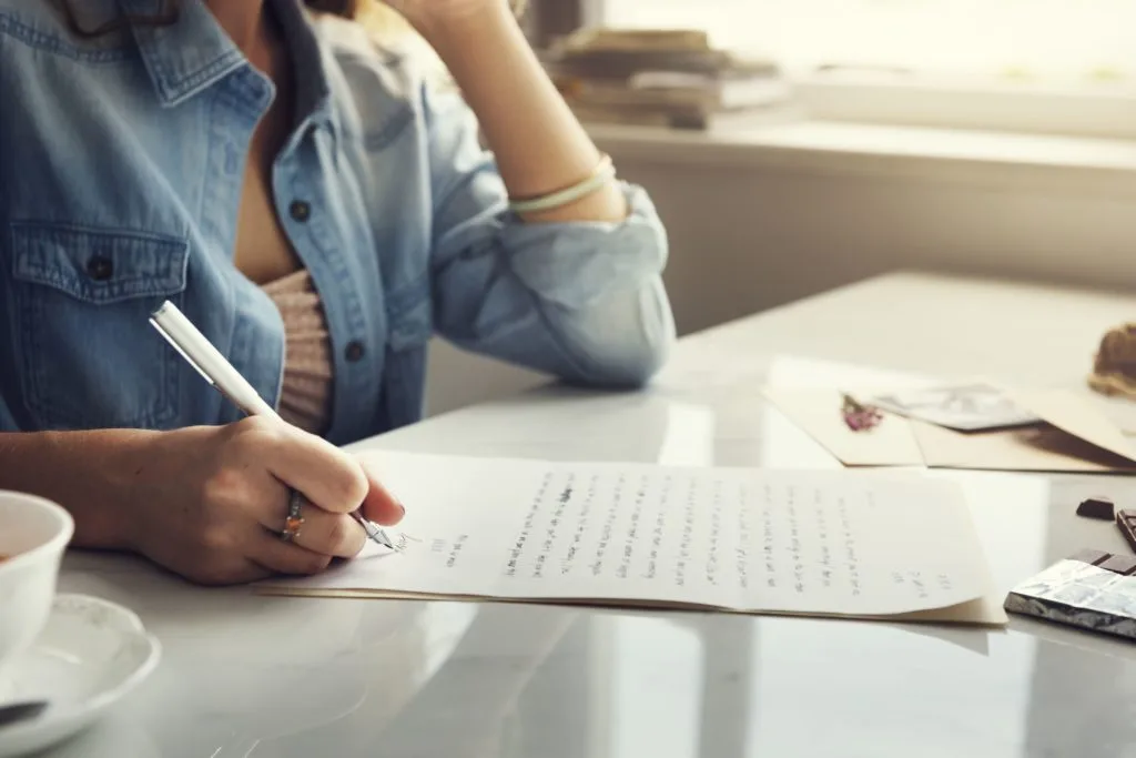 Mujer escribiendo una carta de recomendación para un familiar