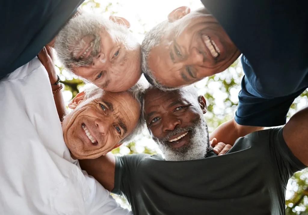 Hombres mayores abrazados sonriendo celebrando su diversidad