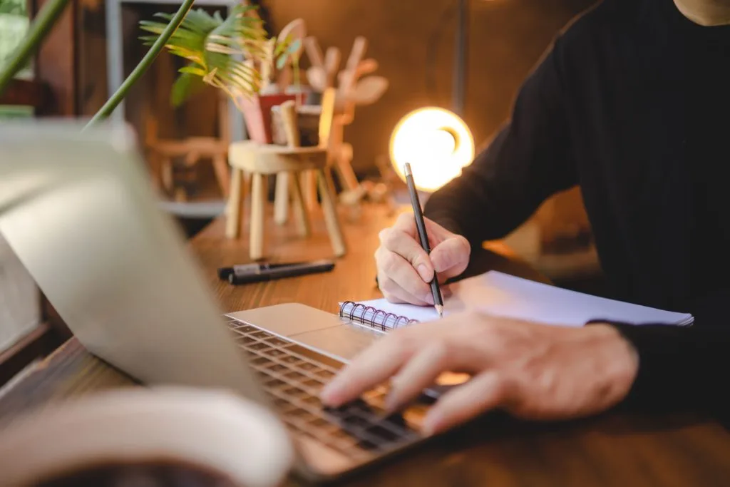 Hombre utilizando su laptop mientras redacta una carta de recomendación para migración
