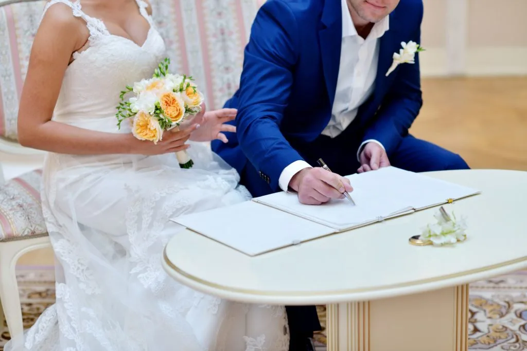 Marido y mujer firmando documentos de registro civil