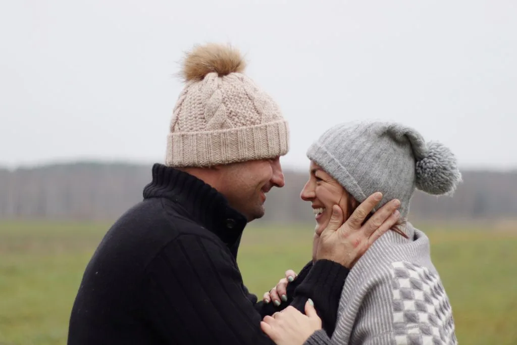 Pareja feliz sonriéndose mutuamente al aire libre