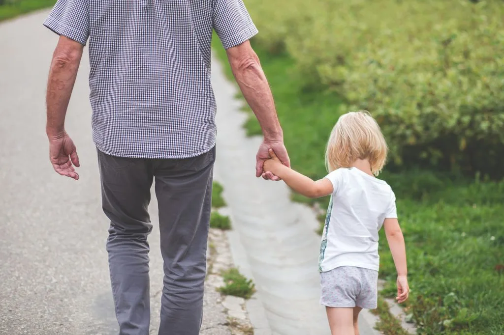 Padre e hija caminando tomados de la mano